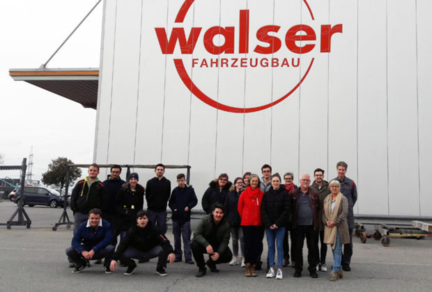 Bild: Team des IAZ Röthis vor dem Firmengebäude der Walser Fahrzeugbau.