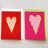 Bild: 2 Karten in rot und rosa mit Herz-Motiv. 