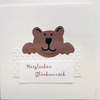 Bild: Karte mit Aufschrift „herzlichem Glückwunsch“ und braunem Bär.